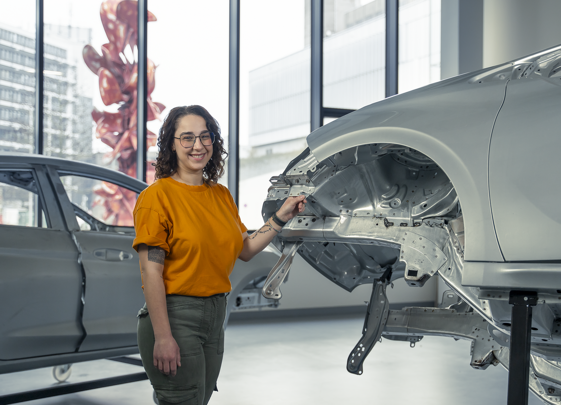 Studentin Maschinenbau vor Autokarosserie