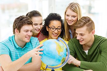 [Translate to Englisch:] Eine Gruppe Studierender betrachtet einen Globus