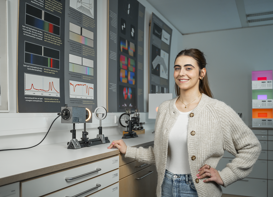 Studentin der Physik vor optischem Versuchsaufbau