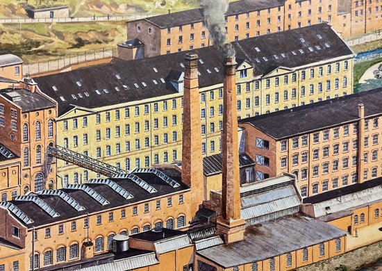 Historische Darstellung eines weitläufigen Fabrikgeländes mit mehrstöckigen Backsteingebäuden, großen Fensterreihen und zwei hohen Schornsteinen, aus einem davon steigt Rauch auf. Im Vordergrund liegen weitere Werkhallen mit schrägen, verglasten Dachflächen.