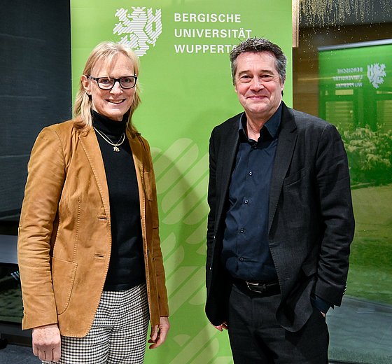 Prof. Dr. Birgitta Wolff und Prof. Dr. Rainer Forst vor dem verglasten Eingang des Johannes Rau-Zentrums